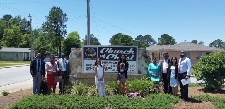 Group of people in front of Church of Christ sign